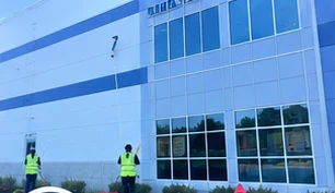 Crew members working outside a newly finished commercial building with landscaped frontage