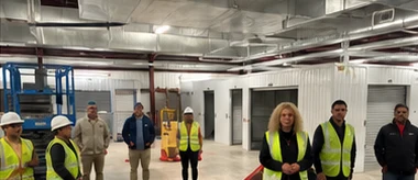 A 10dow Clean team gathered inside a large warehouse with cleaning carts and equipment